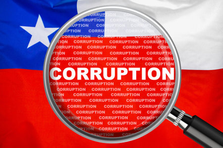 Magnifying glass focused on the word corruption on Chile flag background. Corruption and another financial concept in Chileの写真素材