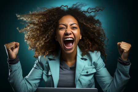 Happy afro american woman with laptop - embodying the concepts of success and victoryの素材
