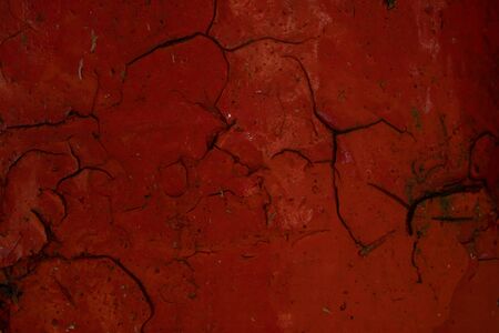Old bloody red cracked paint.Abstract texture.Creepy background.Urban design.Naturally broken.Aged paint.の写真素材