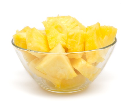 Pineapple chunks in the bowl isolated on whiteの写真素材