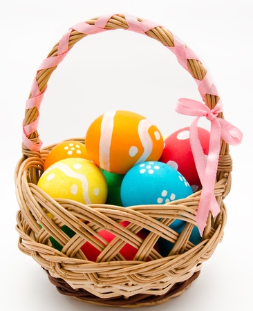Colorful painted easter eggs in basket isolated over whiteの写真素材