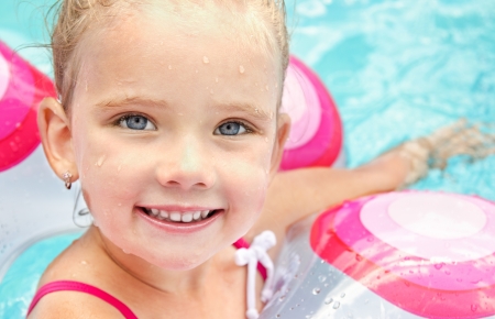 Pretty smiling little girl in swimming pool の写真素材