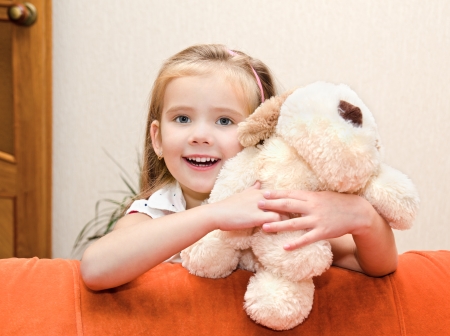 Cute smiling little girl having fun with her toy at homeの写真素材