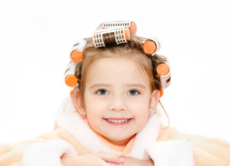 Portrait of smiling cute little girl in hair curlers and bathrobeの写真素材