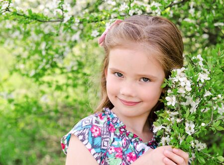 Portrait of adorable smiling little girl outdoorの写真素材