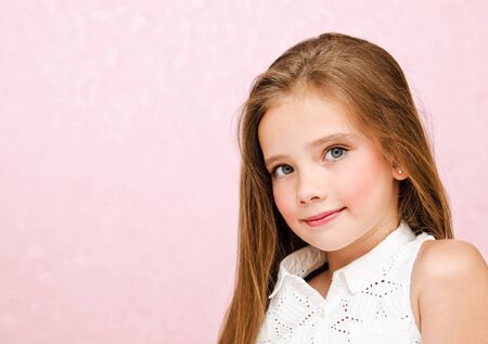 Portrait of adorable smiling little girl child schoolgirl teenager in dress with long hair standing...