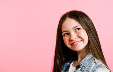 Portrait of adorable smiling little girl child isolated on a pink backgroundの写真素材