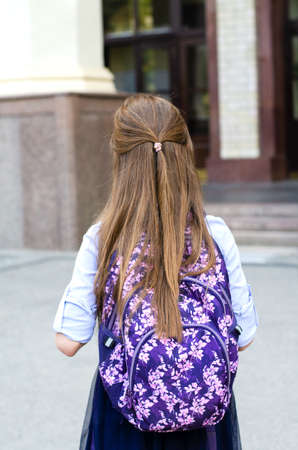 Back to school. Education concept. Cute smiling schoolgirl on the way to the school back view.  Happy little girl child with backpackの写真素材