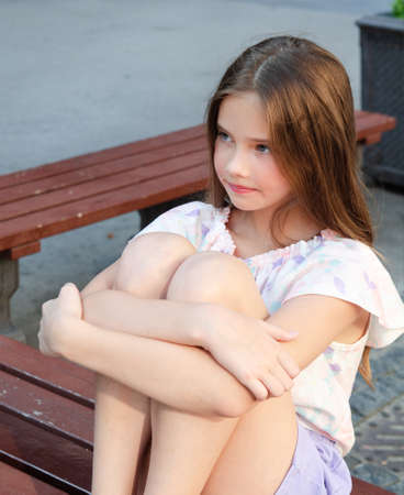 Portrait of sad upset little girl child in the summer day outdoors
