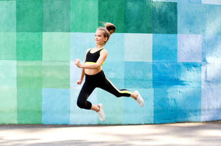 Fitness sport young girl in sportswear doing yoga fitness exercise on a wall background. Sporty...