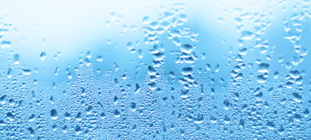 Water drops on glass. Blue abstract wall background. Texture banner with space for textの写真素材
