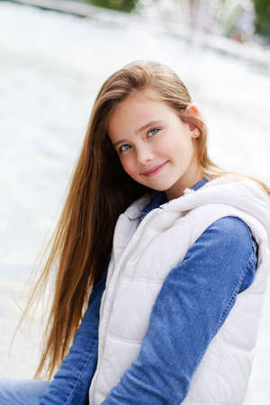 Portrait of adorable smiling girl child preteen in the park outdoors closeupの写真素材