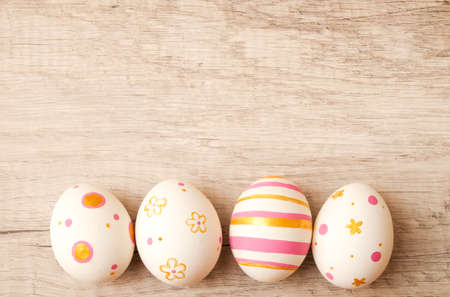 Colorful perfect handmade painted easter eggs on a wood background. Top view and copy spaceの写真素材