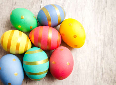 Colorful handmade painted easter eggs on a wood background. Top viewの写真素材