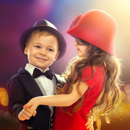 Lovely little boy and girl dancing in lights of the city  Love, friendship conceptの写真素材