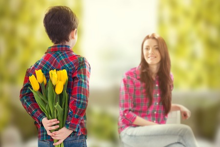 Rear view lad with bunch of beautiful tulips behind back preparing nice surprise for his mother Mother s day concept Family holiday Rear view lad with bunch of beautiful tulips behind back preparing nice surprise for his mother Mother s day concept Family holiday