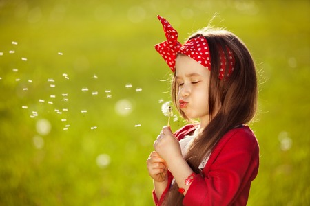 Beautiful little girl blowing dandelion  Happiness, fashionable concept の写真素材