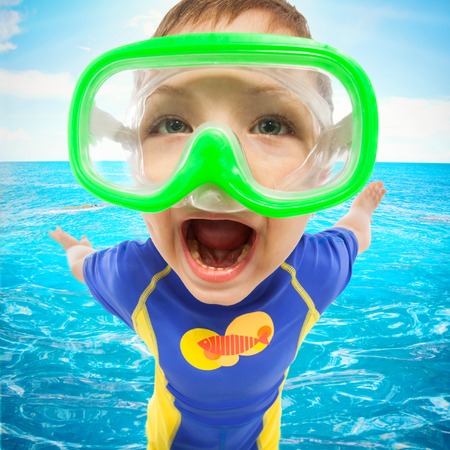 Happy little boy with face mask at sea. Travel and summer vacation conceptの写真素材