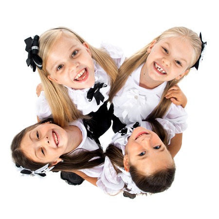 Group of smiling schoolgirls in school uniform, isolated on white background. Education, fashion, friendship concept.の写真素材