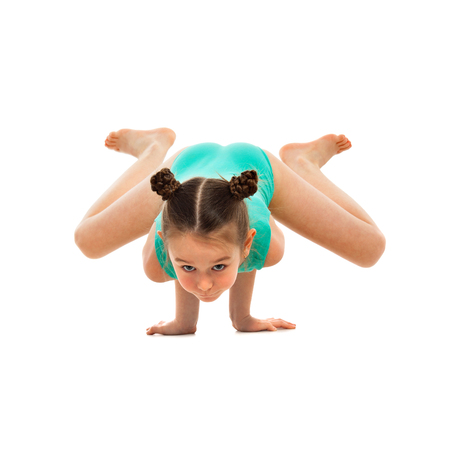 Flexible little girl gymnast doing acrobatic feat, isolated on white background. Sport, active lifestyle conceptの写真素材