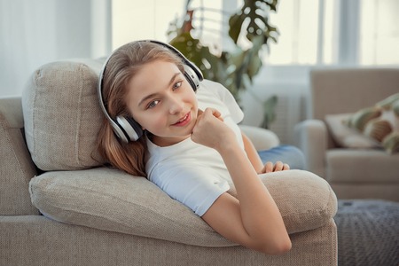 Beautiful teenage girl with smartphone and headphones listening music.の写真素材