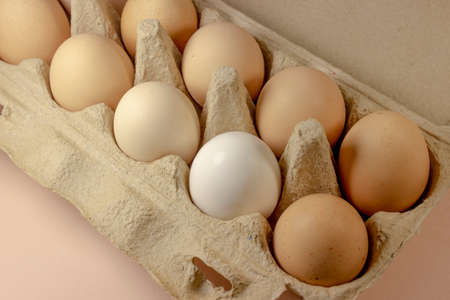 Brown and white eggs lie on a light background.
