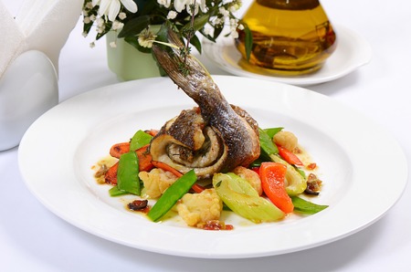 Sea bass fillet with spring vegetables and olive sauceの写真素材
