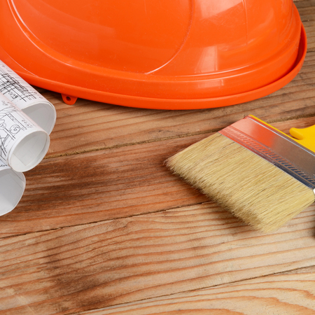 Construction helmet and brush on woodenの写真素材