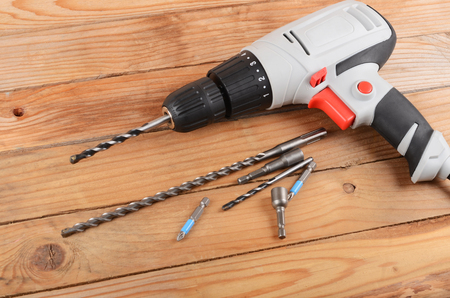 The new electric drill on wooden backgroundの写真素材