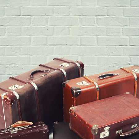 Old suitcases on a brick wall backgroundの写真素材