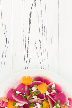 Colorful and healthy watermelon radish, orange and goat cheese carpaccio salad. Top view, free text copy spaceの写真素材