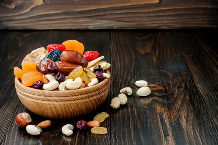 Mix of dried fruits and nuts on dark wood background with copy space. Symbols of judaic holiday Tu Bishvatの写真素材