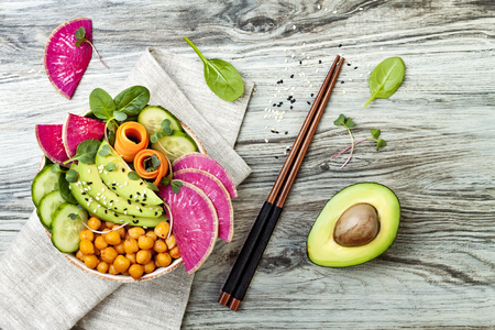 Vegan, detox Buddha bowl recipe with avocado, carrots, spinach, chickpeas and radishes. Top view, flat lay, copy spaceの写真素材