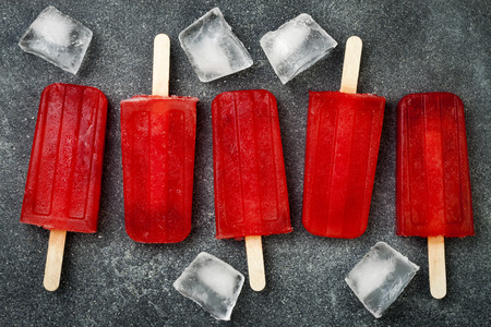 Homemade frozen blood orange natural juice alcoholic popsicles - paletas - ice pops. Overhead, flat...