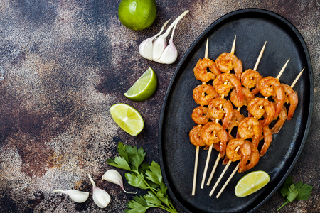 Grilled spicy lime shrimp skewers with creamy avocado garlic cilantro sauce. Top view, overhead, flat lay, copy spaceの写真素材