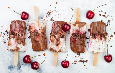 Black Forest chocolate fudge popsicles with roasted cherries and coconut cream. Vegan creamy ice pops, nicecream, fudgesiclesの写真素材