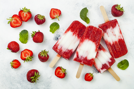 Homemade vegan strawberry coconut milk popsicles - ice pops - paletas on rustic white backgroundの写真素材