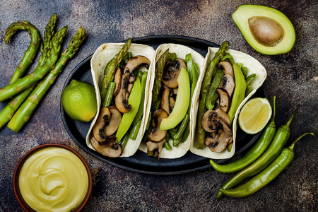 Grilled portobello, asparagus, bell peppers, green beans fajitas. Poblano mushroom tacos with jalapeno, cilantro, avocado crema. Vegan tacos with green summer vegetables.の写真素材