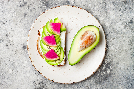 Avocado and watermelon radish toast with chia seeds. Healthy green veggie breakfast sanddwich. Top view, overheadの写真素材