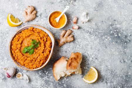 Traditional red lentil Dal. Indian Dhal spicy curry in bowl with flat bread and spices. Top view, overheadの写真素材