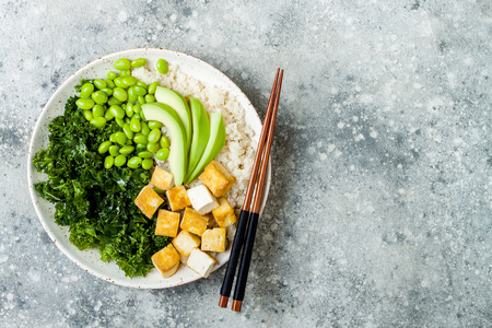 Cauliflower rice Buddha bowl with massaged kale, tofu, avocado and edamame beans. Vegan poke bowlの写真素材