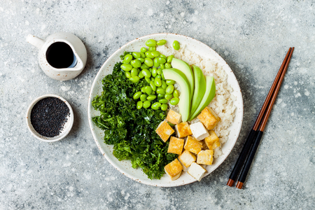 Cauliflower rice Buddha bowl with massaged kale, tofu, avocado and edamame beans. Vegan poke bowlの写真素材