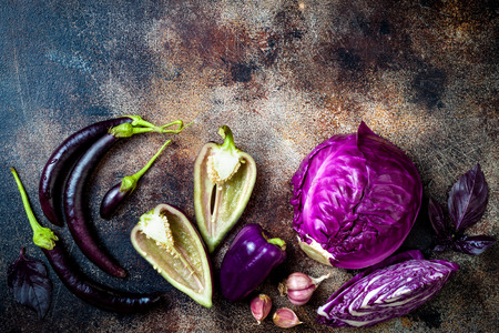 Raw purple seasonal vegetables over rustic background. Top view, flat lay, copy spaceの写真素材