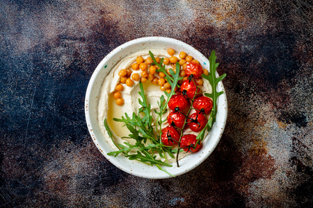 Homemade hummus with roasted cherry tomatoes. Middle Eastern traditional and authentic arab cuisine. Top view, copy spaceの写真素材
