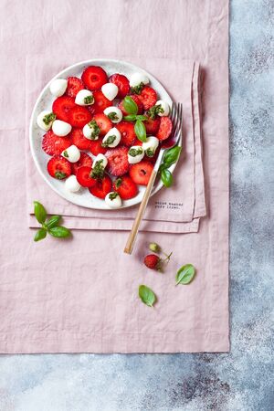 Summer fruit caprese salad with strawberries. Strawberry salad with basil pesto and mozzarella.の写真素材