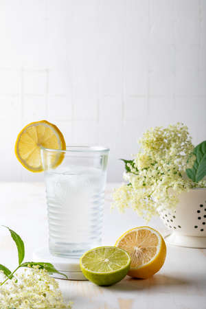 Glass of homemade elderflower lemonade with lemon, lime juice and freshly picked elderberry flowers.の写真素材