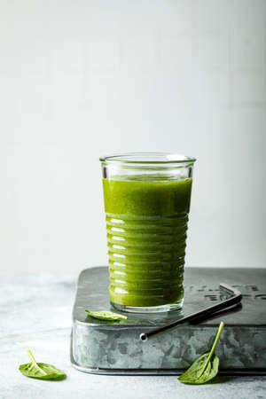 Green vegan smoothie with ginger and spinach in glass. Clean eating, detox, dieting, vegetarian, vegan, healthy weight loss food conceptの写真素材