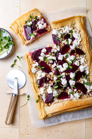 Beetroot and feta filo pizza. Beet Tart with feta, caramelized onion, pine nuts, sunflower micro greens and phyllo dough. Savory vegetable vegetable baking.の写真素材