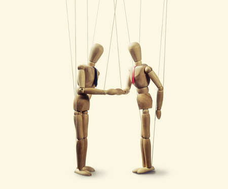 two puppets  shakes hands at the conclusion of the deal on toned isolated backgroungの写真素材