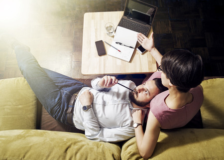 Teamwork. The man thinks, lying on woman's lapの写真素材